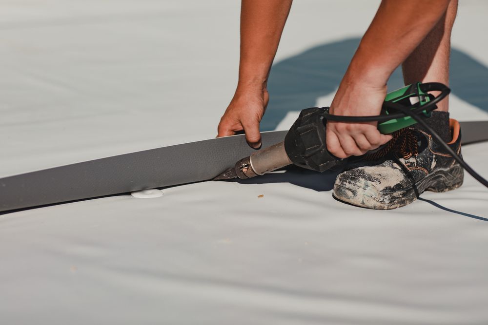 A person is welding a piece of foam on a roof.