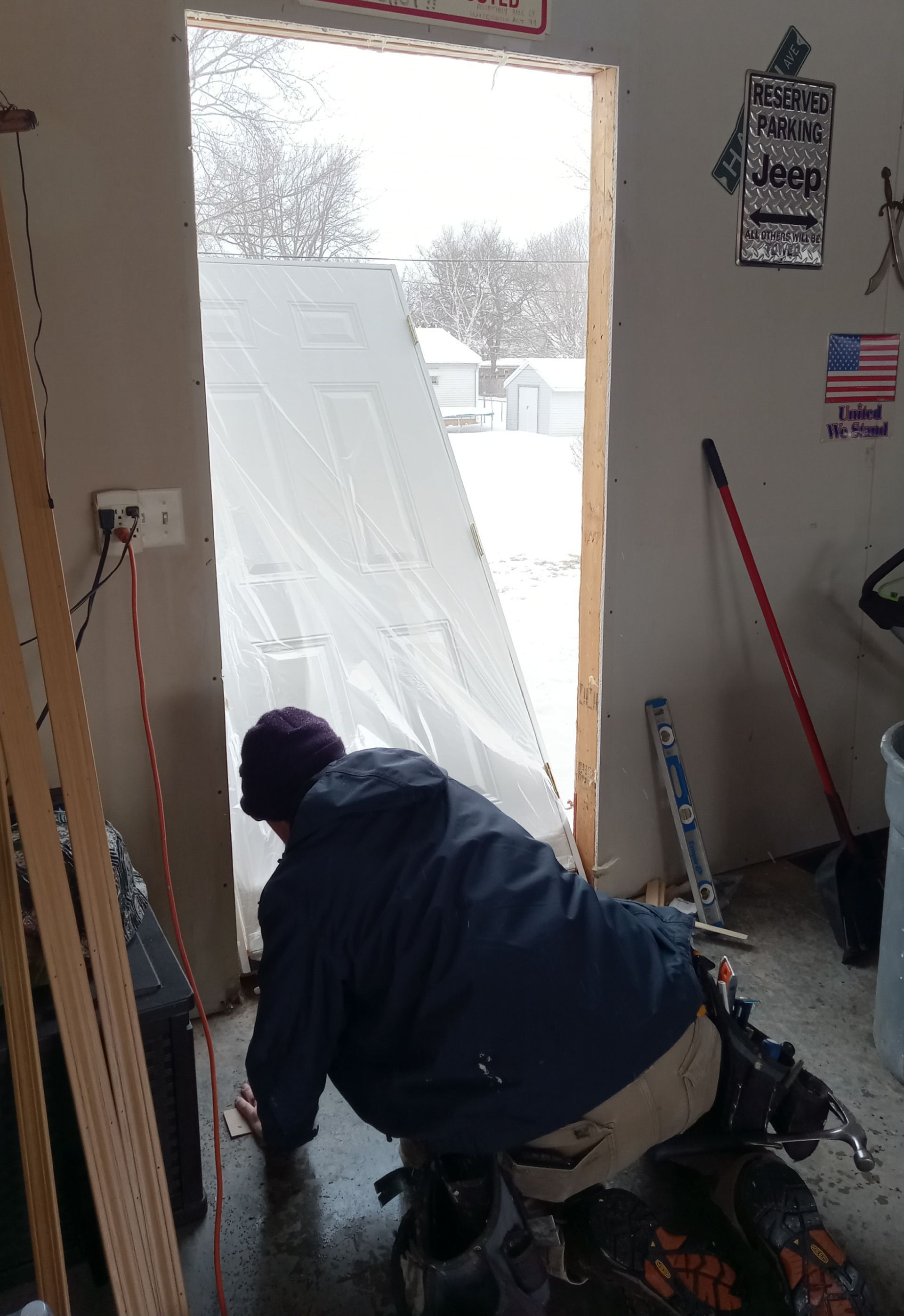 A man is working on a door in a garage.