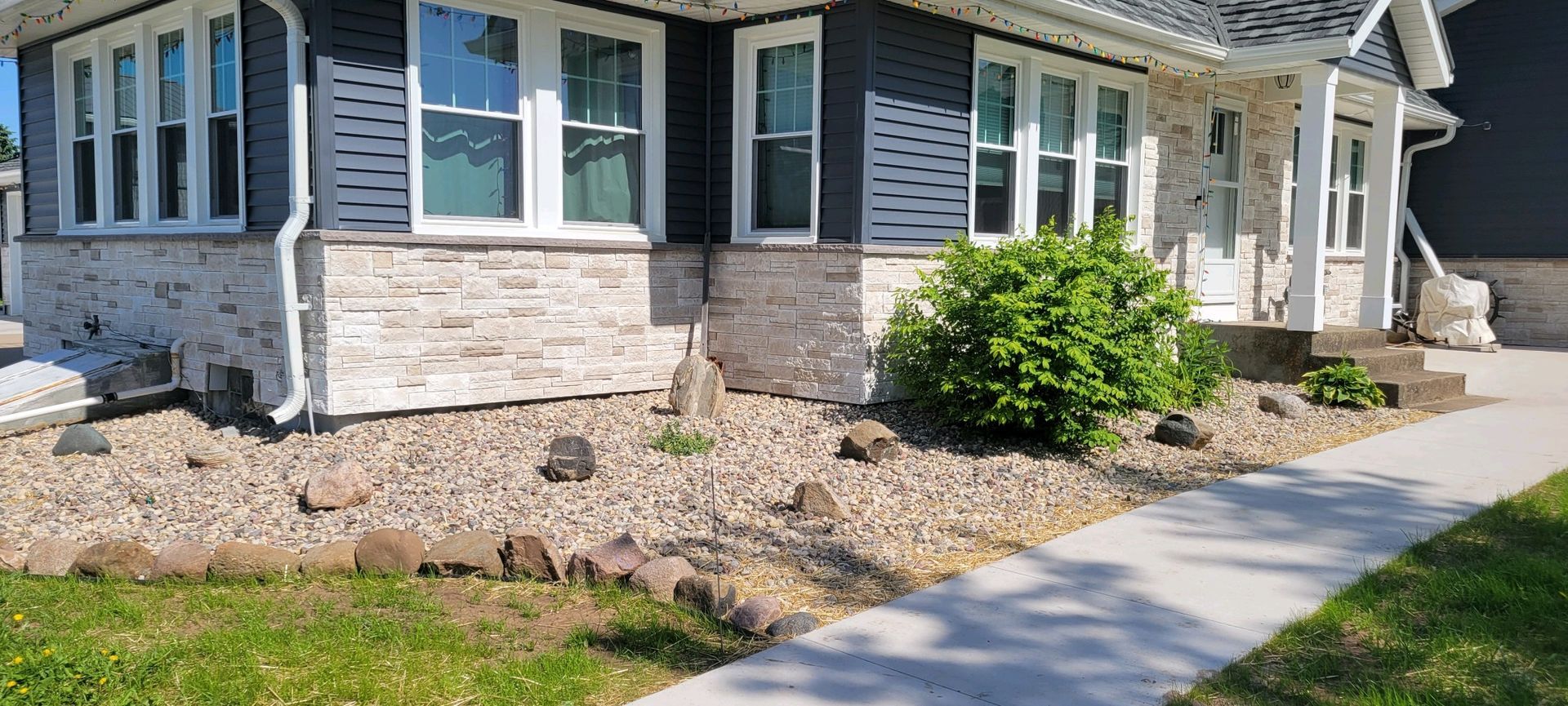 A house with a walkway leading to it and a sidewalk in front of it.