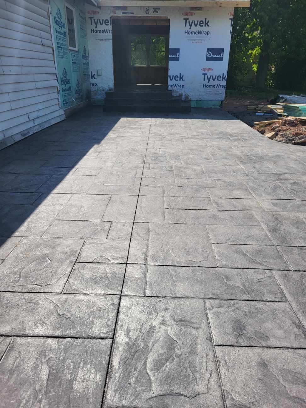 A concrete driveway is being built in front of a house.