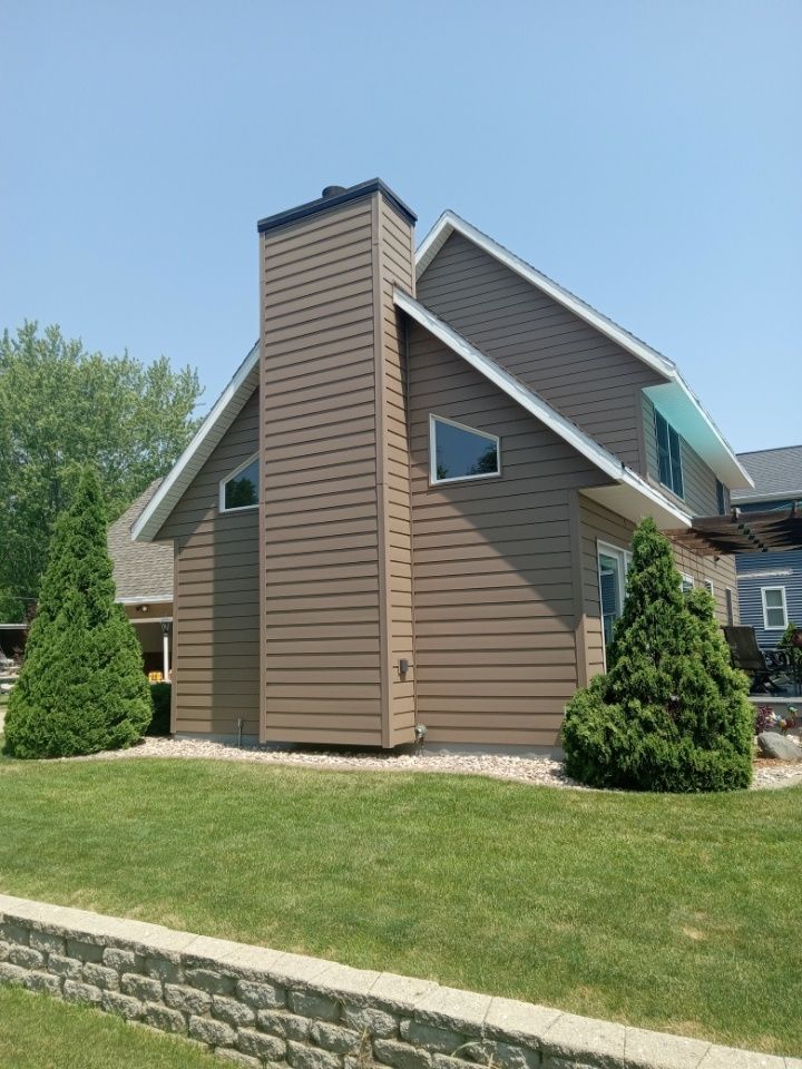 A brown house with a chimney on the side of it