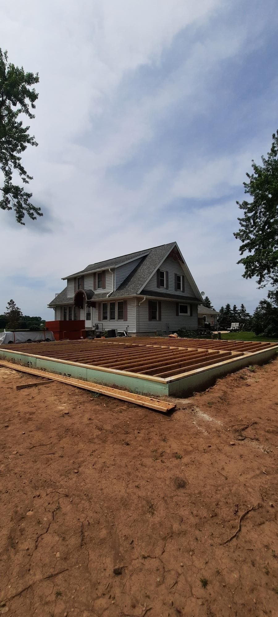 A house is being built in the middle of a dirt field.