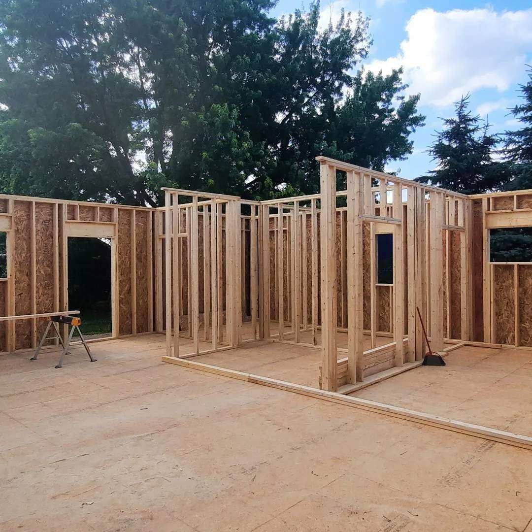 A house is being built with wooden frames and a broom.
