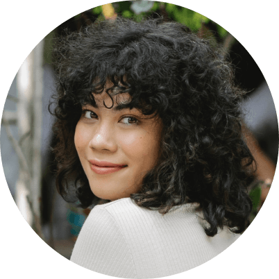 A woman with curly hair is smiling in a circle.