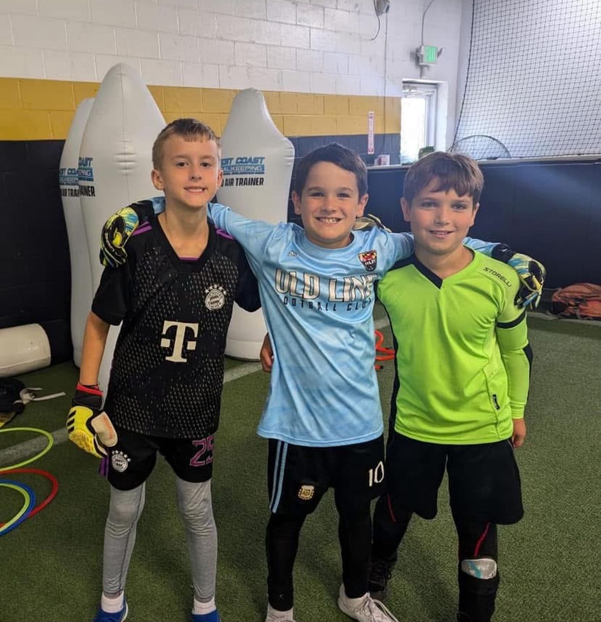 Three young boys posing for a picture with one wearing a t-mobile jersey