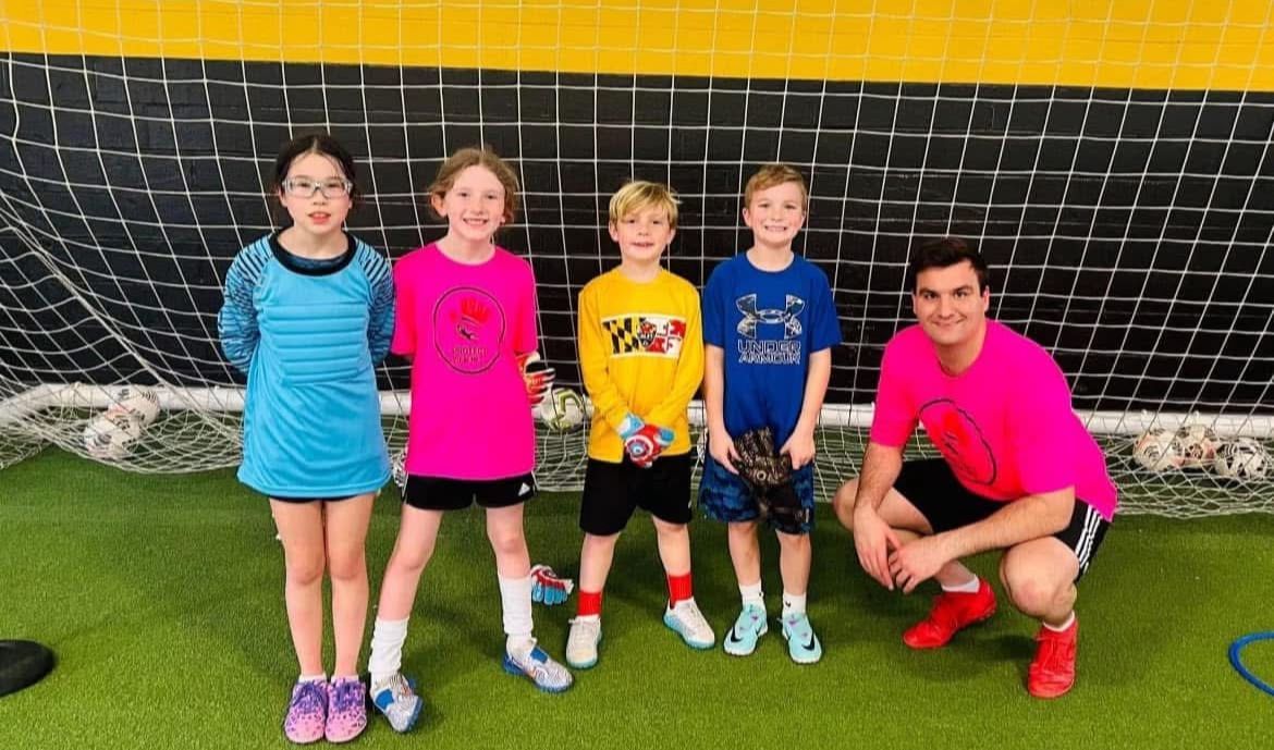 A group of children are posing for a picture in front of a soccer goal.