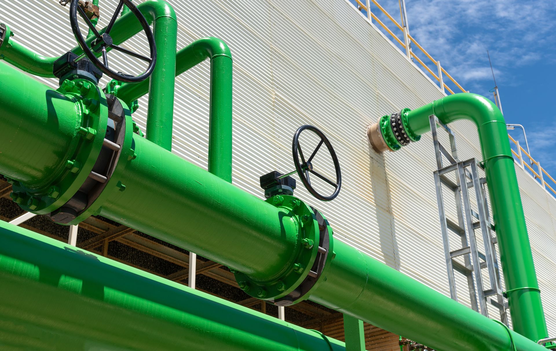 Large green piping system for centrifugal water well pumps for sale at industrial facility. Large green piping system for centrifugal water well pumps for sale at industrial facility.