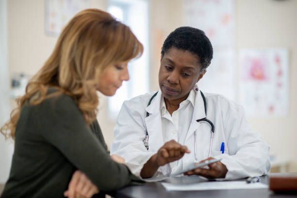 A middle-aged woman sits with her female doctor in her office in San Antonio, TX, by Ob-Gyn Associates P.A.