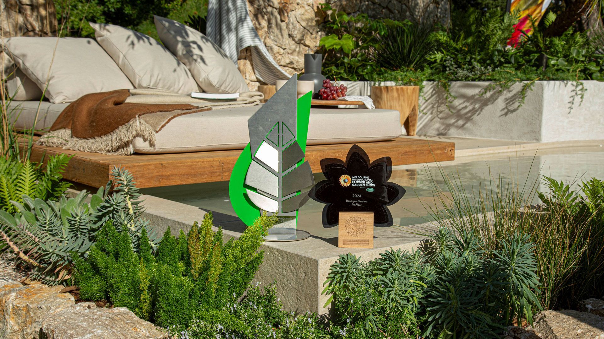 Swimming pool with turquoise water, wood deck, lounge chairs, and green trees under a blue sky.