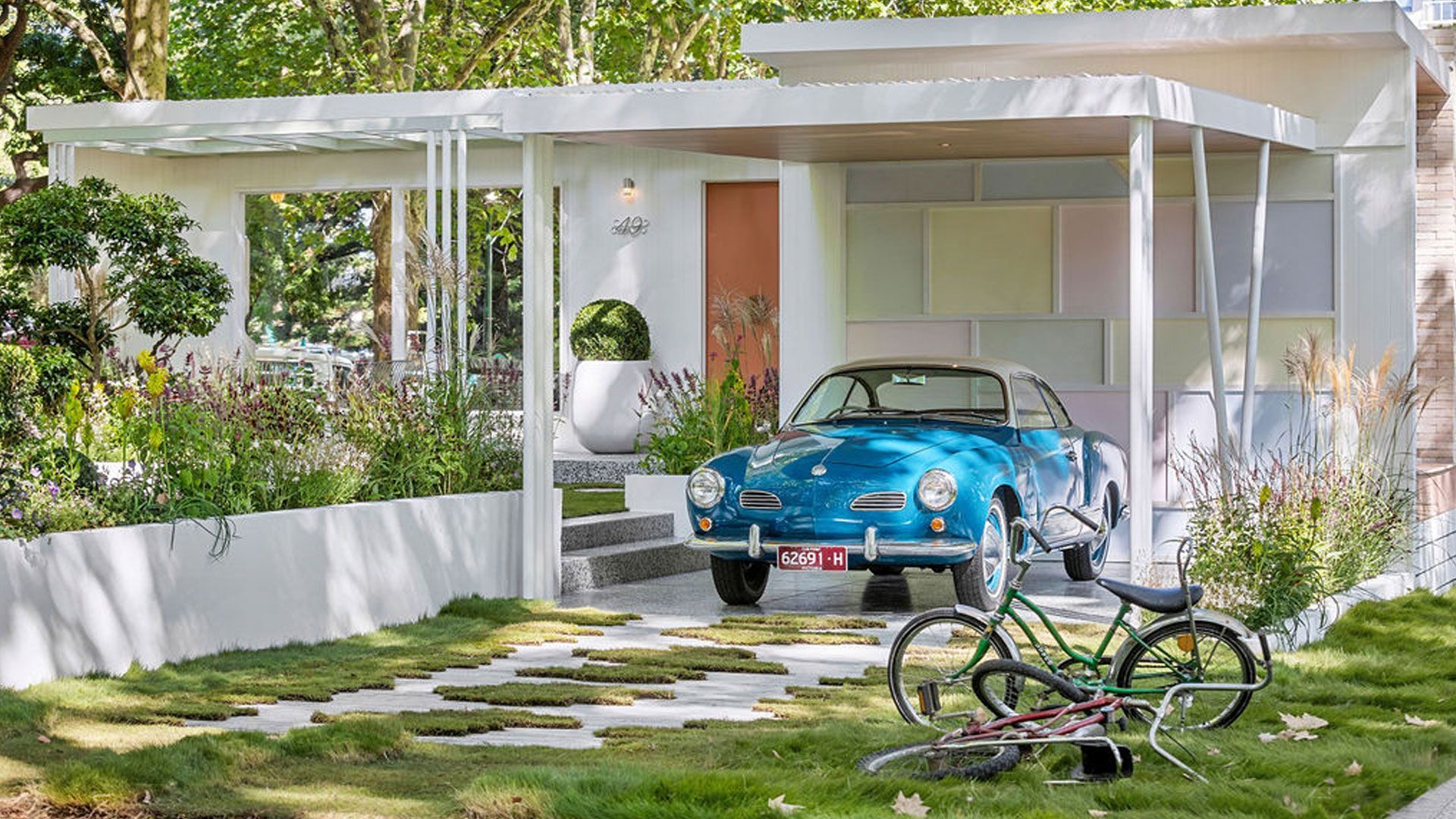 Swimming pool with turquoise water, wood deck, lounge chairs, and green trees under a blue sky.