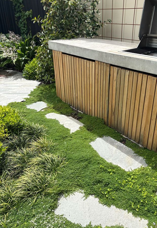 Modern home with pool, lounge area, and dark wood exterior. Sunny outdoor setting.