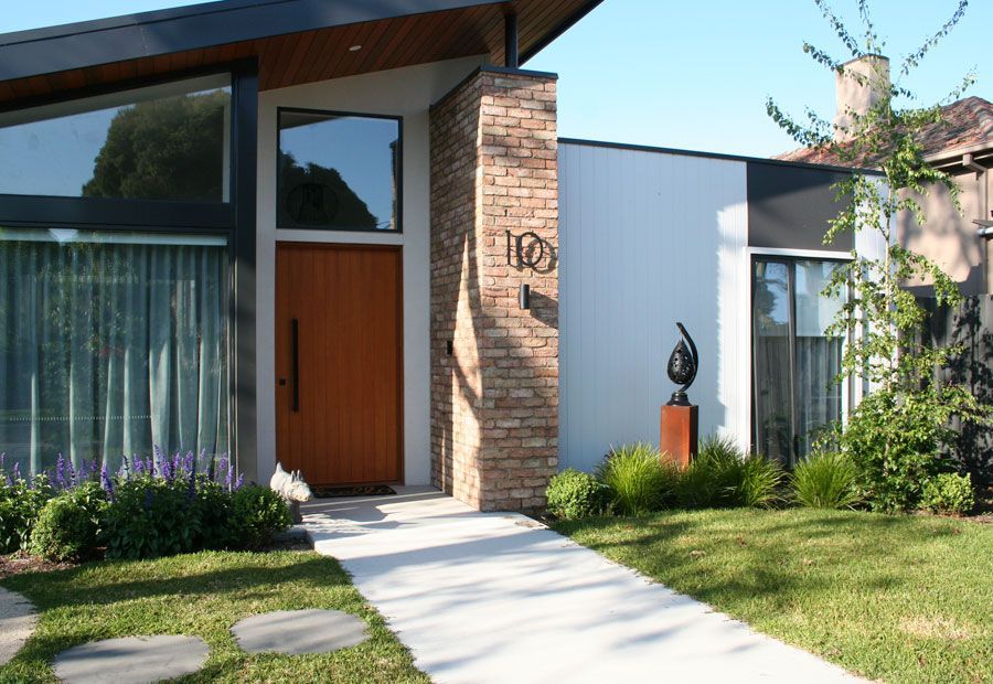 Swimming pool with turquoise water, wood deck, lounge chairs, and green trees under a blue sky.