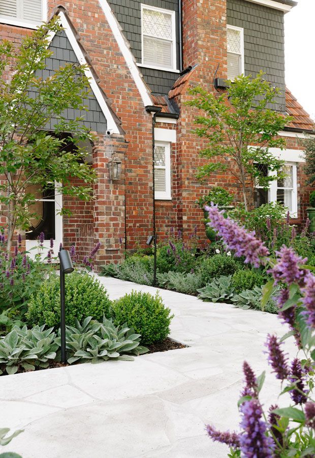 Modern house with pool, shaded patio, and wooden pergola. Turquoise water, glass walls, and dark wood siding.