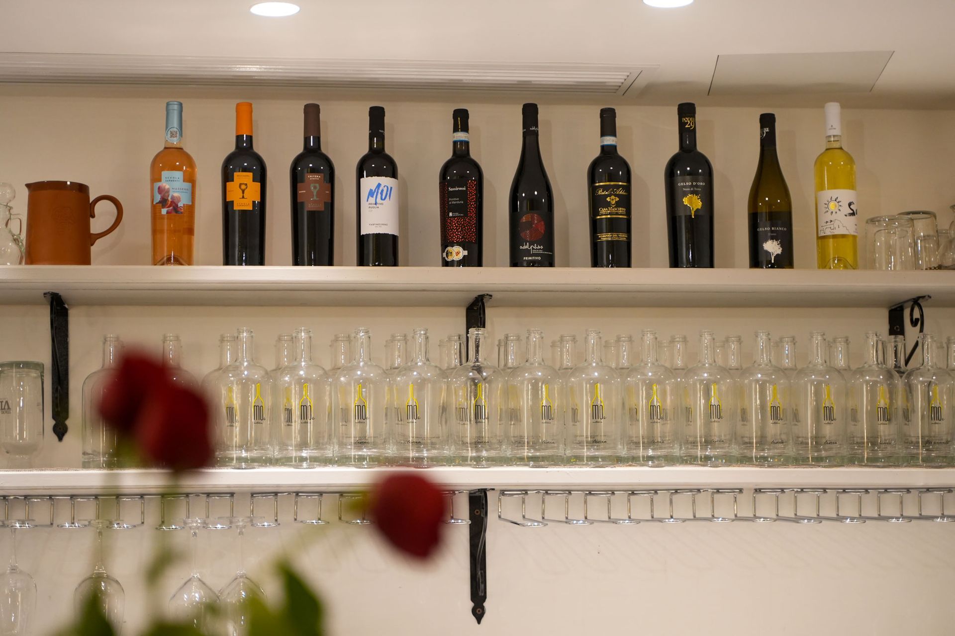 scaffali con bottiglie di vino e calici