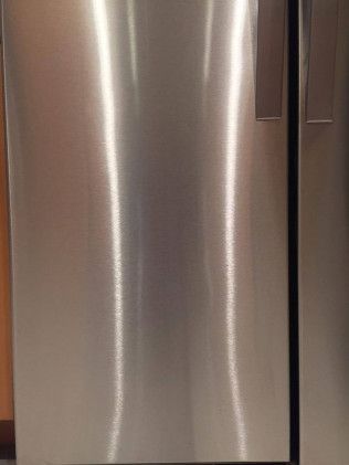 A close up of a stainless steel refrigerator door in a kitchen.