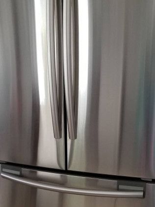 A close up of a stainless steel refrigerator door.