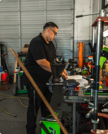 A man in a black shirt is working in a garage | Driven Auto Care