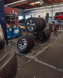 Tires are stacked on a rack in a garage | Driven Auto Care