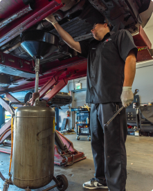 A man is working under a car in a garage | Driven Auto Care