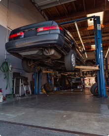 A car is sitting on a lift in a garage | Driven Auto Care