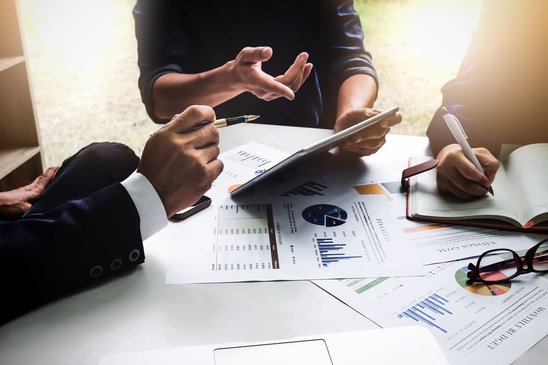 People discussing documents and charts at a bright office table