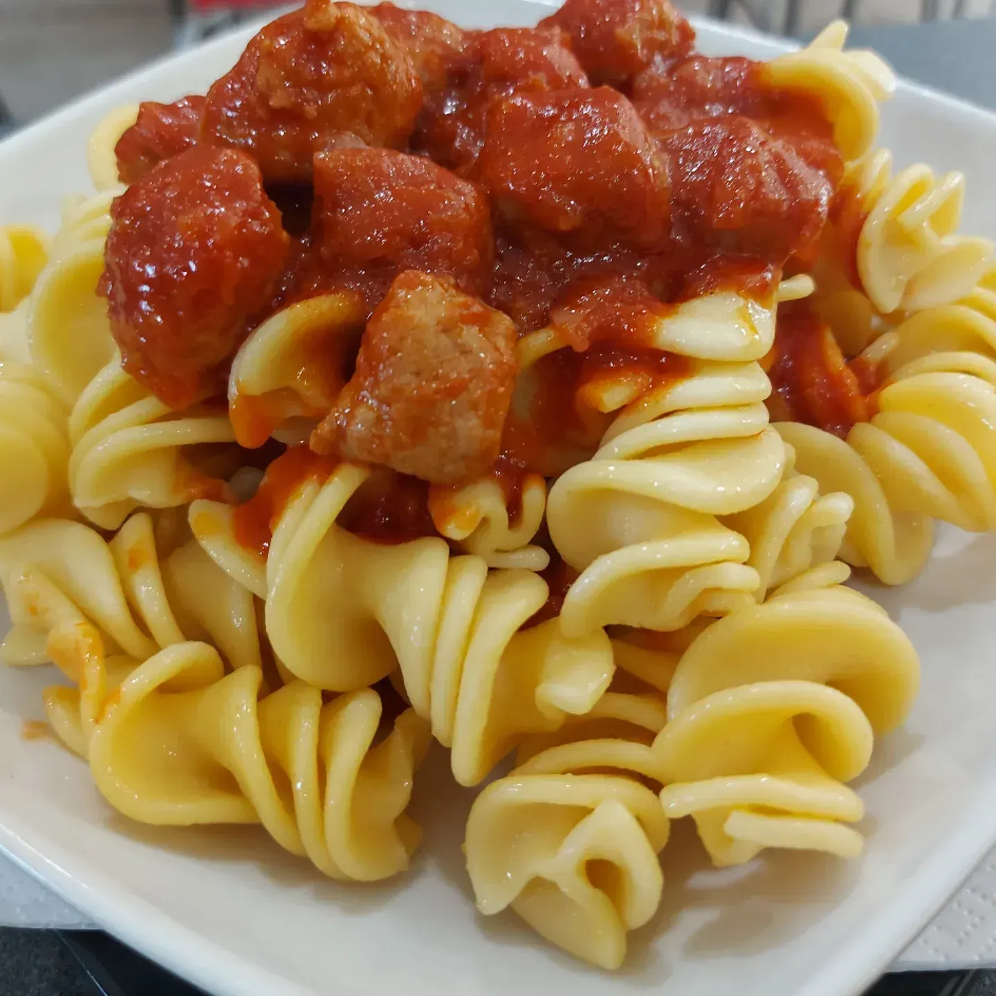 Un piatto di pasta con polpette e salsa sopra