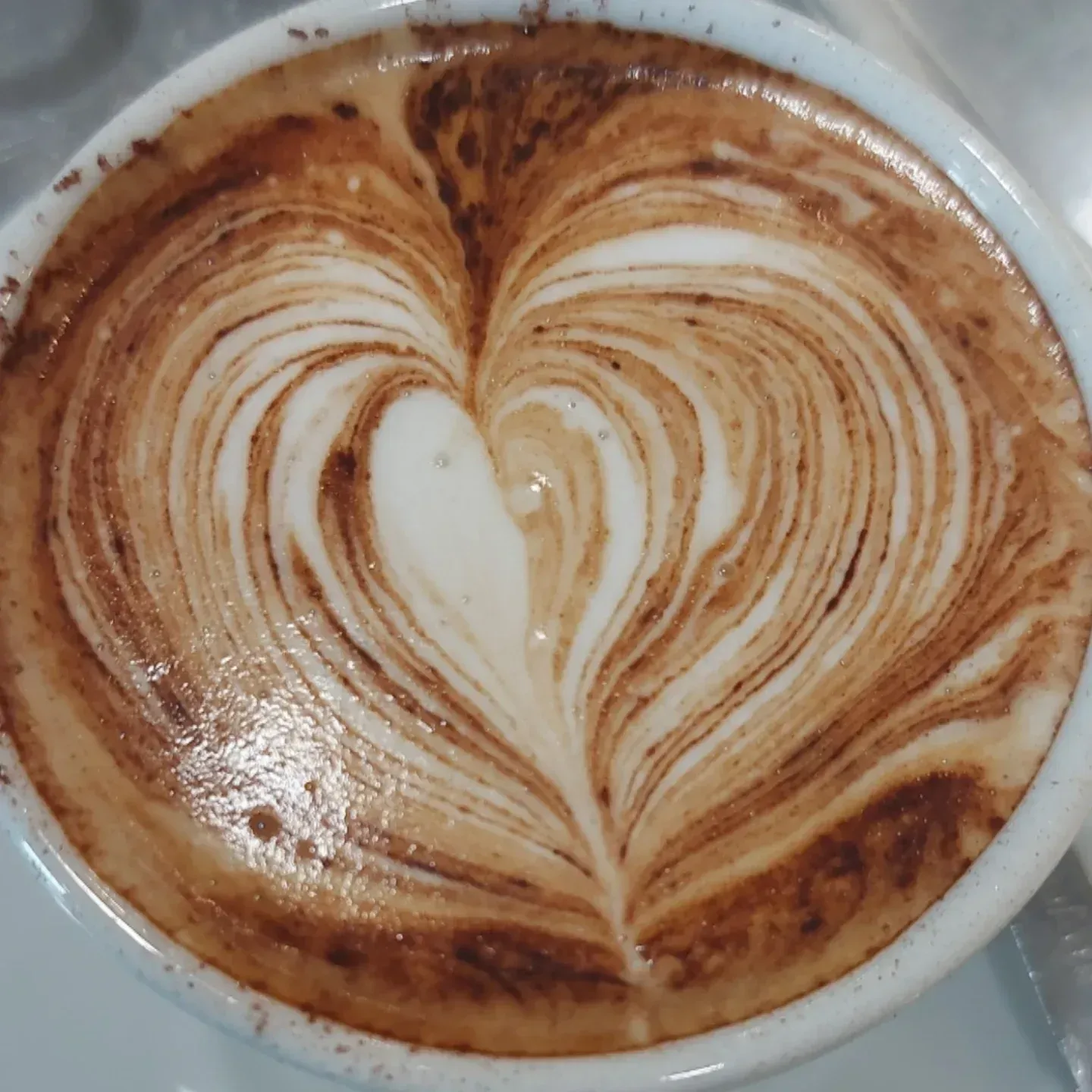 Una tazza di caffè con un latte art a forma di cuore