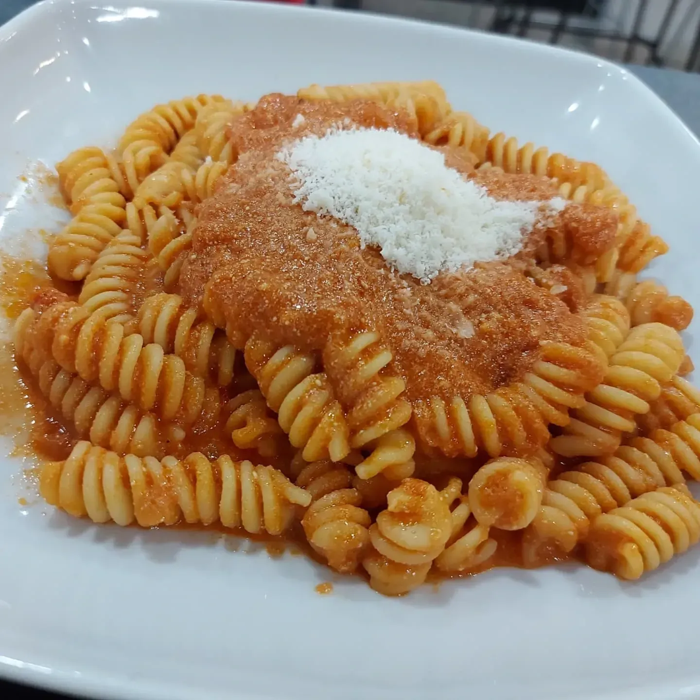 Un piatto di pasta con sugo e formaggio sopra