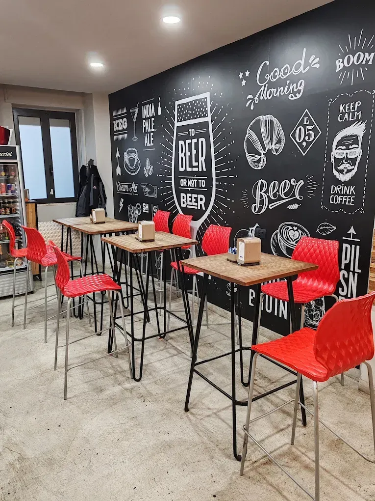 Un ristorante con tavoli, sedie e una parete con lavagna.