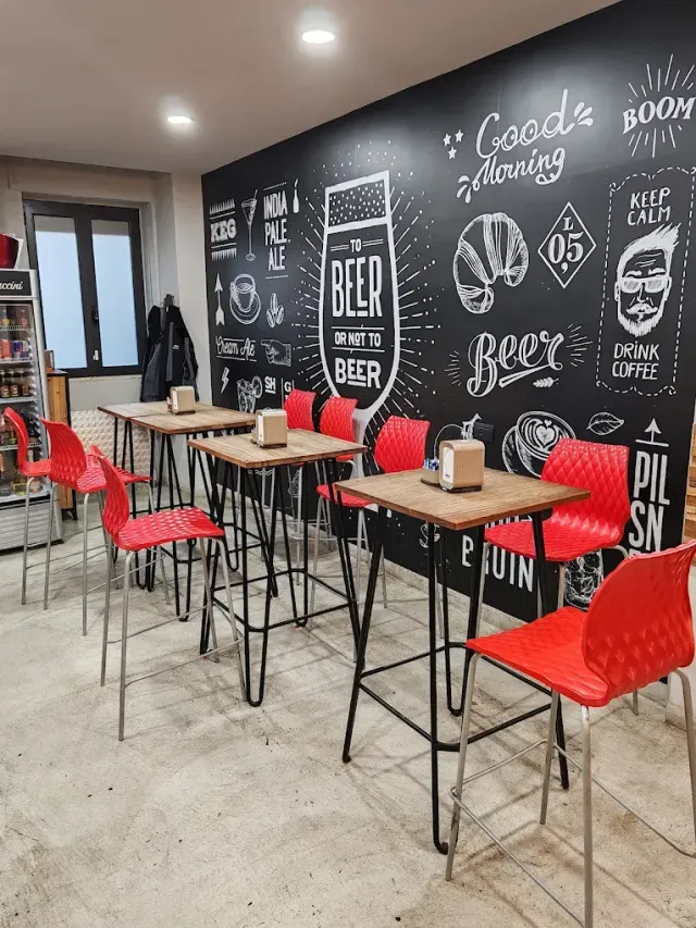 Un ristorante con tavoli, sedie e una parete con lavagna.