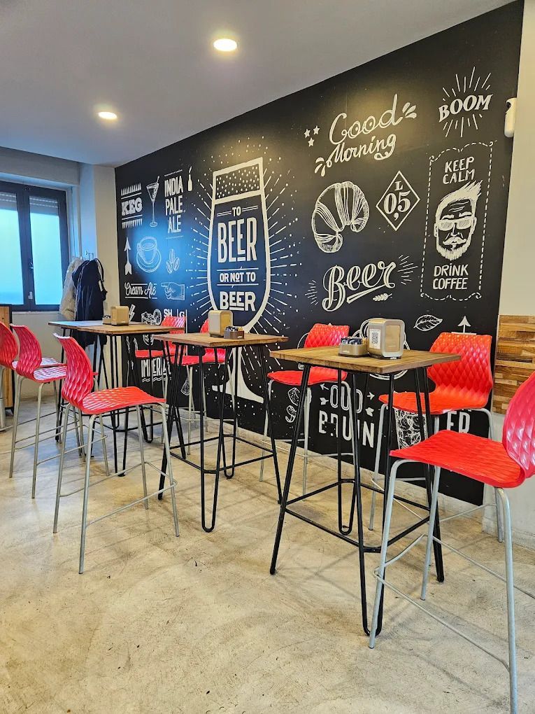 Un ristorante con tavoli, sedie e una parete con lavagna.