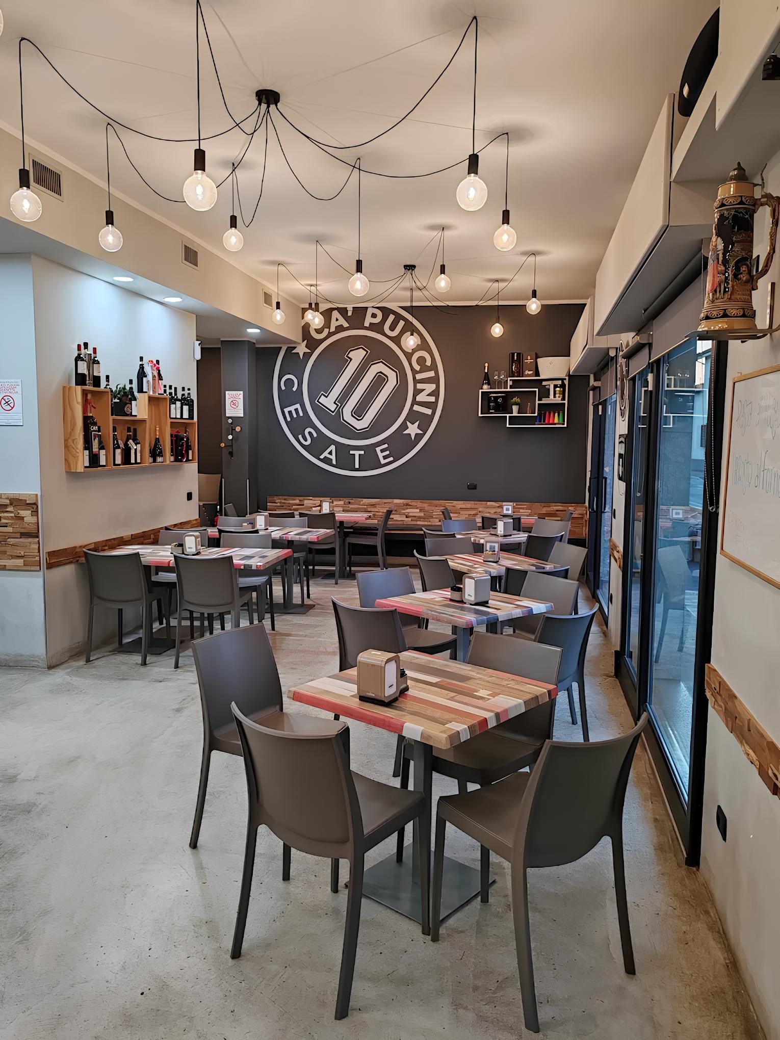 Un ristorante con tavoli e sedie e un logo sul muro.