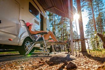 woman relaxing outside of an rv