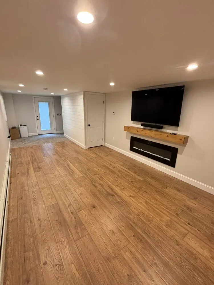 A living room with hardwood floors and a flat screen tv on the wall.