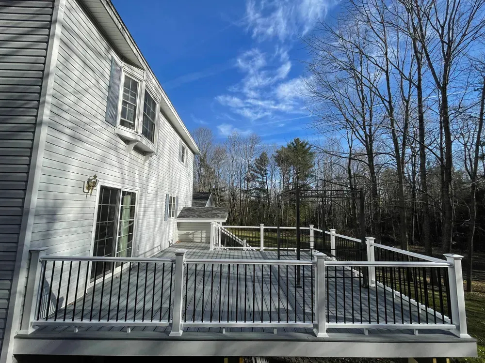 A large white house with a large deck in front of it.