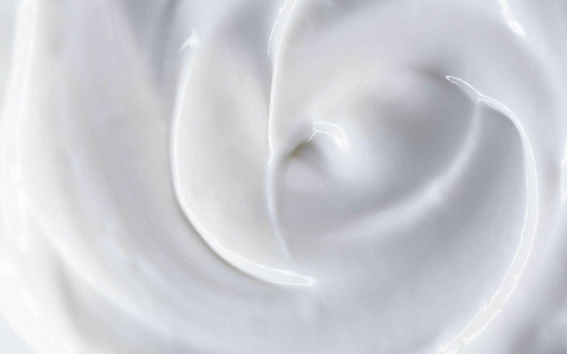 Abstract white swirling liquid or cream texture with soft highlights