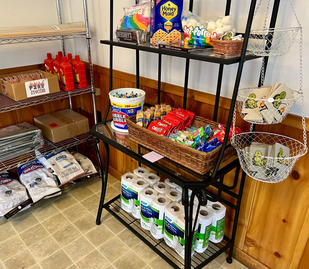 Rustic wooden cabin with porch in a wooded area.