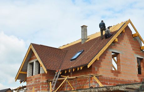 roofer installing roof on house