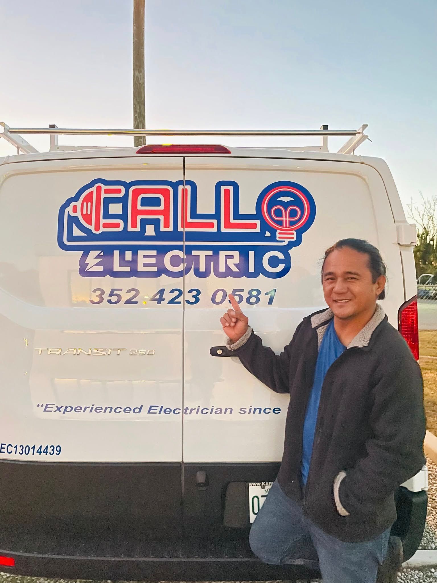 A man is standing in front of a callo electric van
