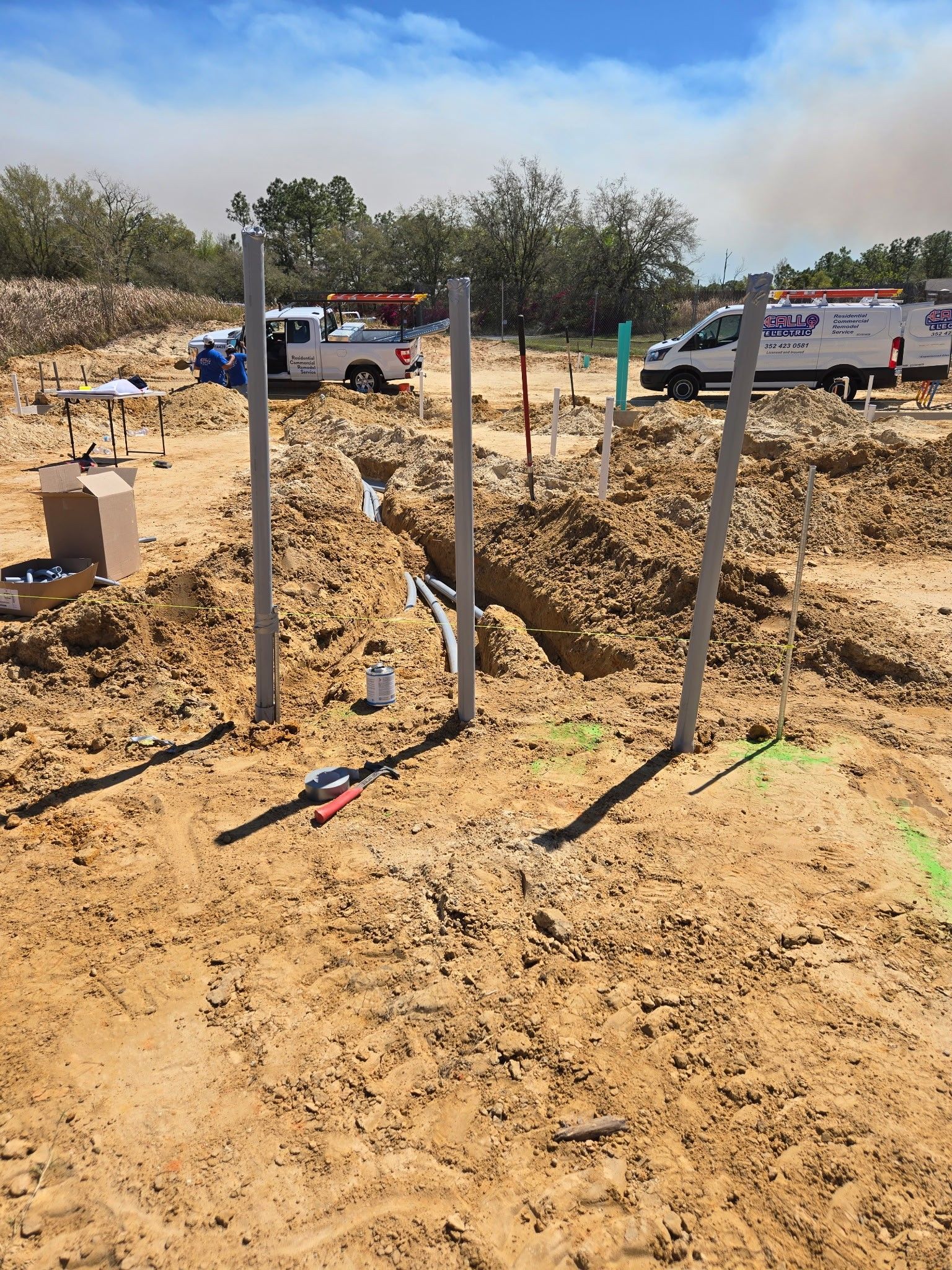 A construction site with a truck and a van in the background.