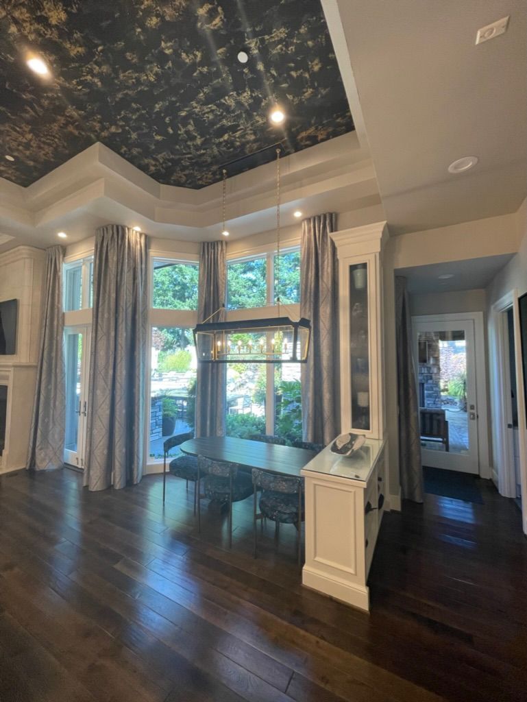 Woman in straw hat smiles, holding wine glass near a lake.