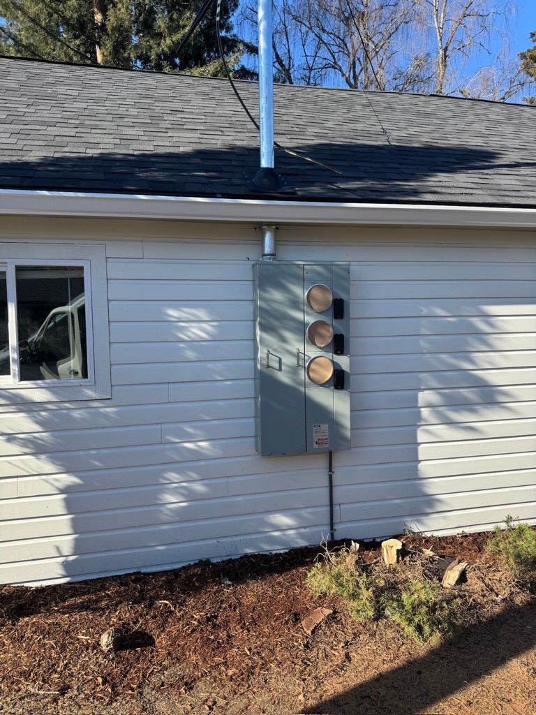 Woman in straw hat smiles, holding wine glass near a lake.