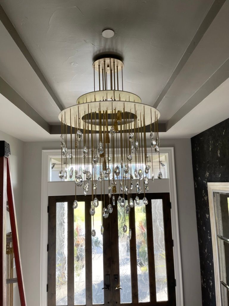 Woman in straw hat smiles, holding wine glass near a lake.