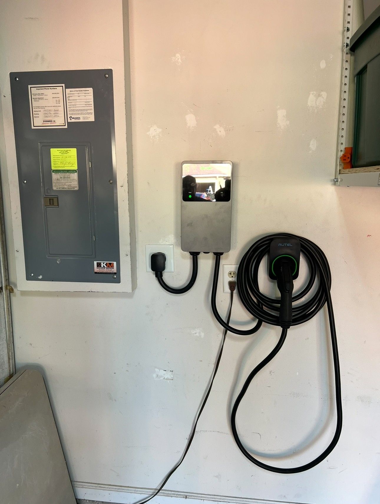 Woman in straw hat smiles, holding wine glass near a lake.