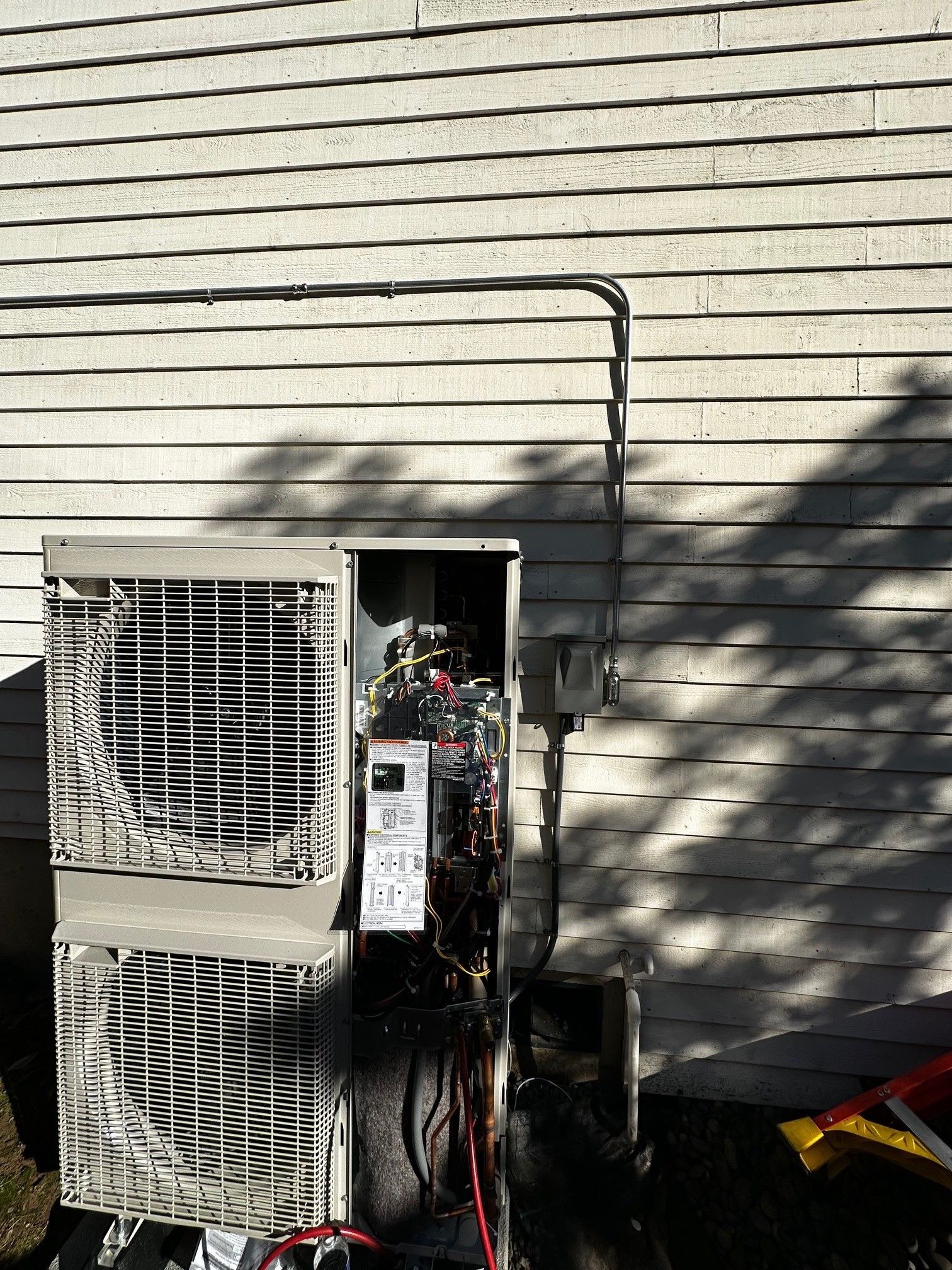Woman in straw hat smiles, holding wine glass near a lake.