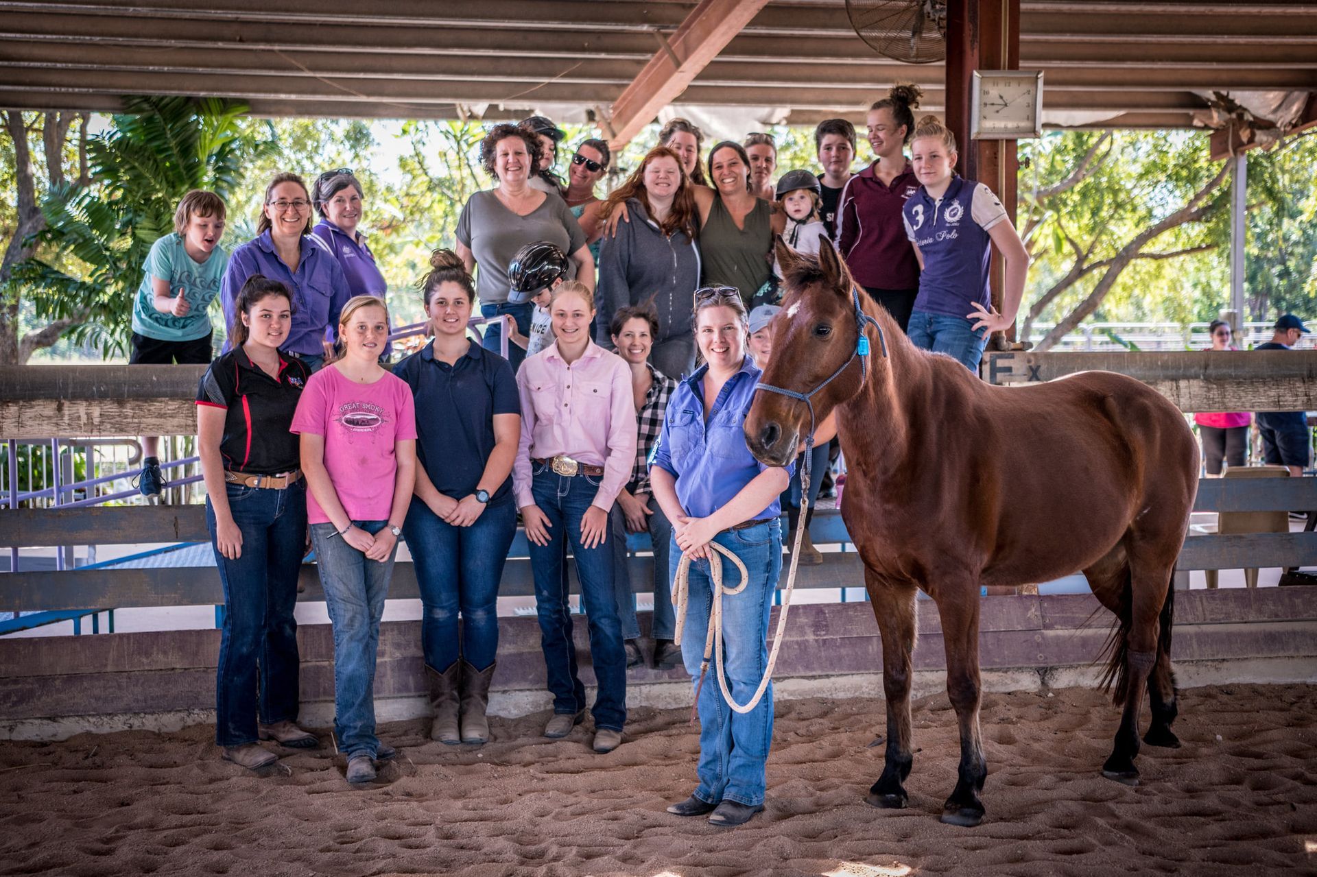 A group of people are posing for a picture with a horse.