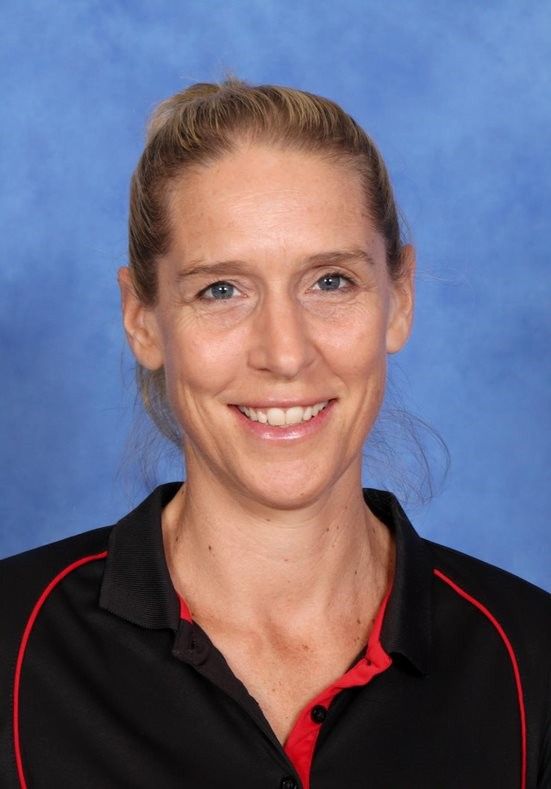 A woman is standing next to a child riding a horse