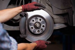 Brake Services — Man Fixing Car Brakes in Hesperia, CA