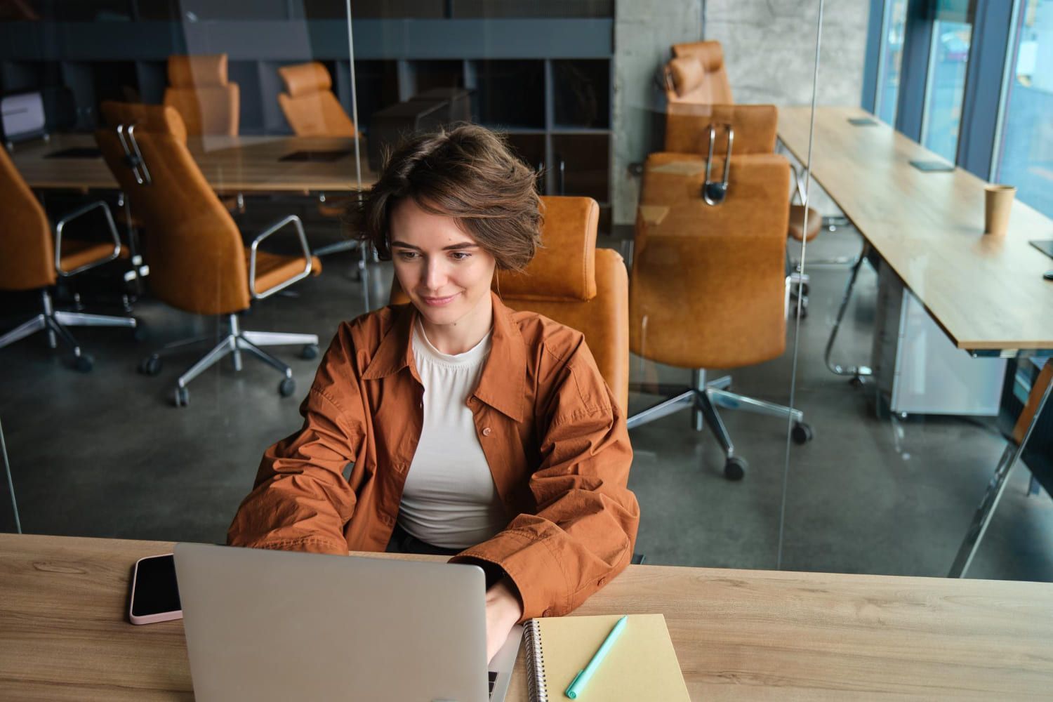 Mulher em um laptop sorri para uma tela com um gráfico intitulado