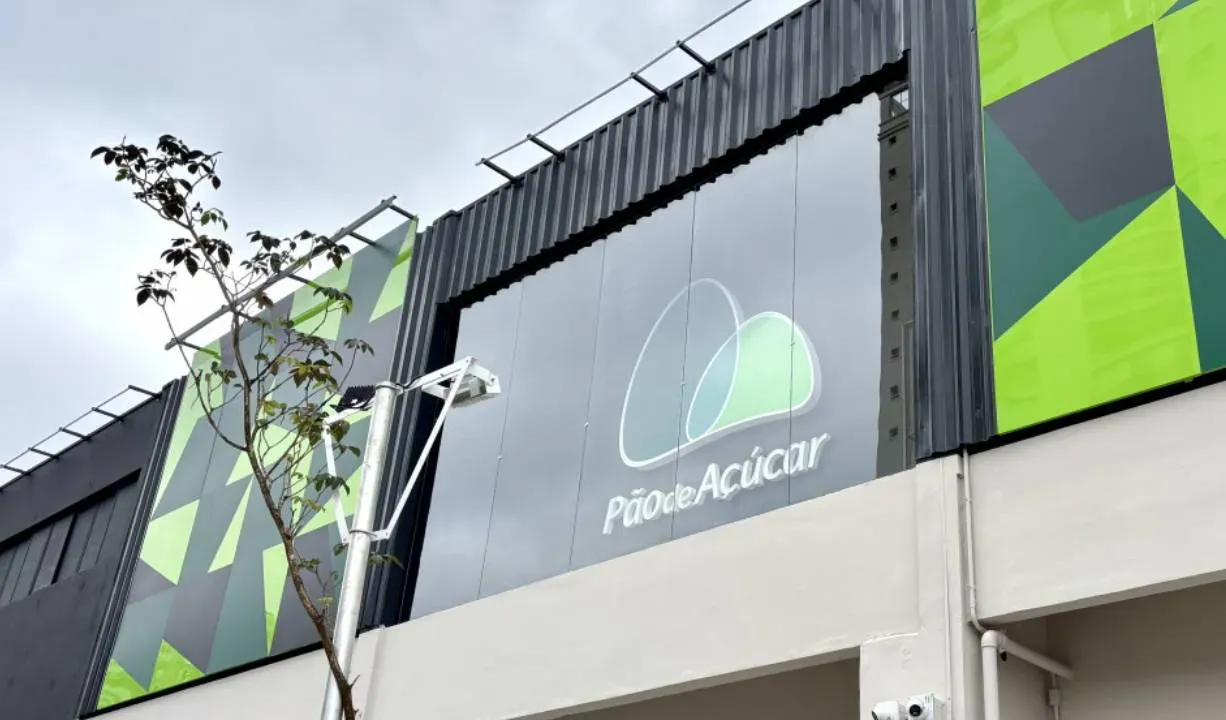 Fachada moderna com painéis geométricos verdes e escrito 